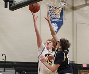  two players reach for a basketball under a net